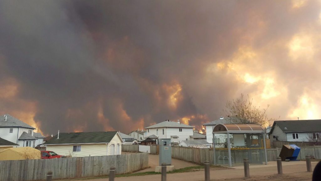 A wall of fire rages outside of Fort McMurray, Alta. Tuesday May 3, 2016 as a wildfire threatened the city. Raging forest fires whipped up by shifting winds sliced through the middle of the remote oilsands hub city of Fort McMurray Tuesday, sending tens of thousands fleeing in both directions and prompting the evacuation of the entire city. THE CANADIAN PRESS/ Mary Anne Sexsmith-Segato