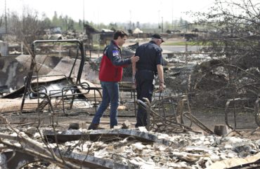Prime Minister Justin Trudeau, left, and Fort McMurray Fire Chief Darby Allen look over the devastation during a visit to Fort McMurray, Alta., on Friday, May 13, 2016. THE CANADIAN PRESS/Jason Franson