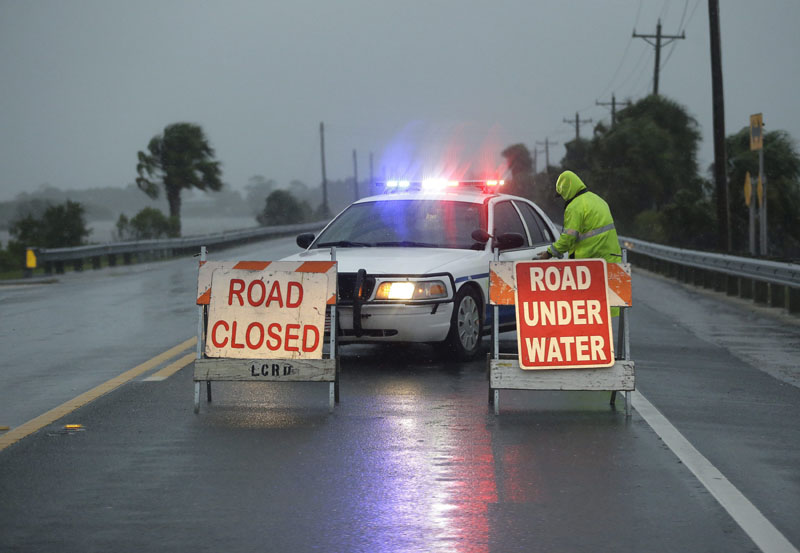 Police block the road entering Cedar Key, Florida, as Hurricane Hermine nears the Florida coast. Hurricane Hermine gained new strength Thursday evening and roared ever closer to Florida's Gulf Coast, where rough surf began smashing against docks and boathouses and people braced for the first direct hit on the state from a hurricane in over a decade. Photo by John Raoux, The Associated Press. 