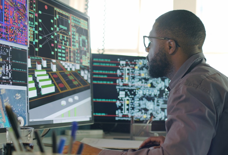 Stock image of an Afro-Caribbean male designing electronic circuit boards ( PCBs).