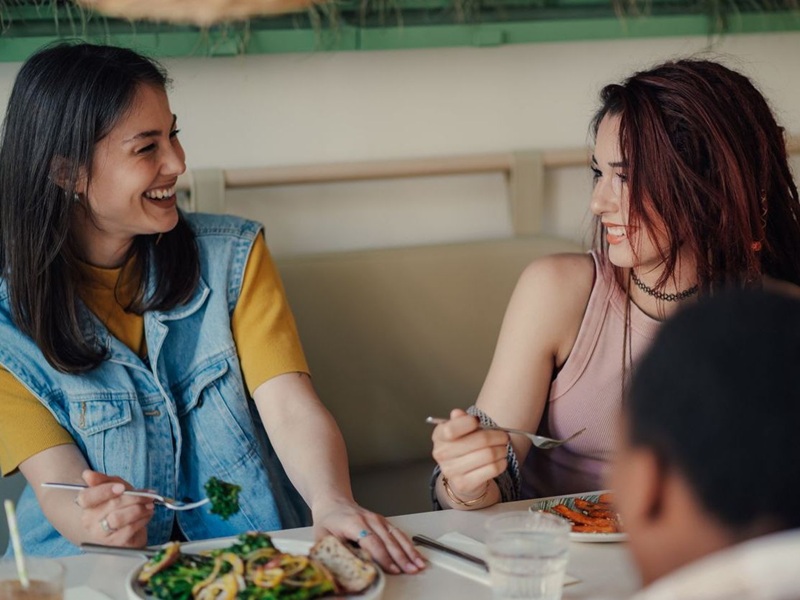 Two young women chatting at a restaurant