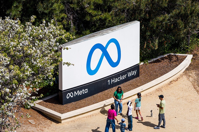Visitors gather at a sign outside Meta headquarters on Thursday, March 26, 2026, in Menlo Park, Calif. (AP Photo/Noah Berger)
