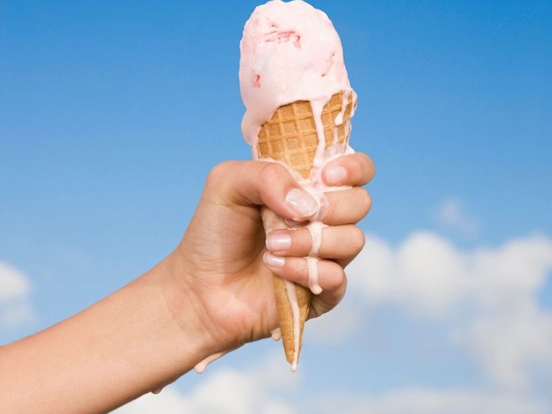 Hand holding a melting ice cream