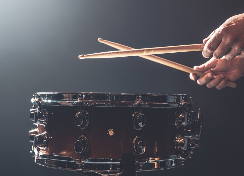 A man plays with sticks on a drum, a drummer plays a percussion instrument, copy space.