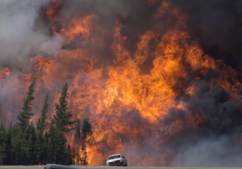 A giant fireball is seen as a wild fire rips through the forest 16 km south of Fort McMurray, Alberta on highway 63 on May 7, 2016. THE CANADIAN PRESS/Jonathan Hayward