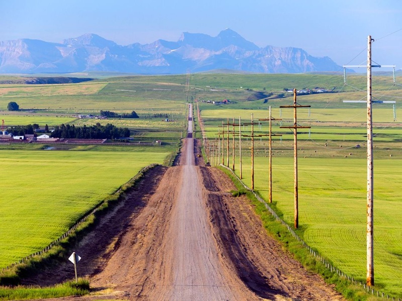 A country road in a rural landscape in Pincher Creek, Alberta, Canada.